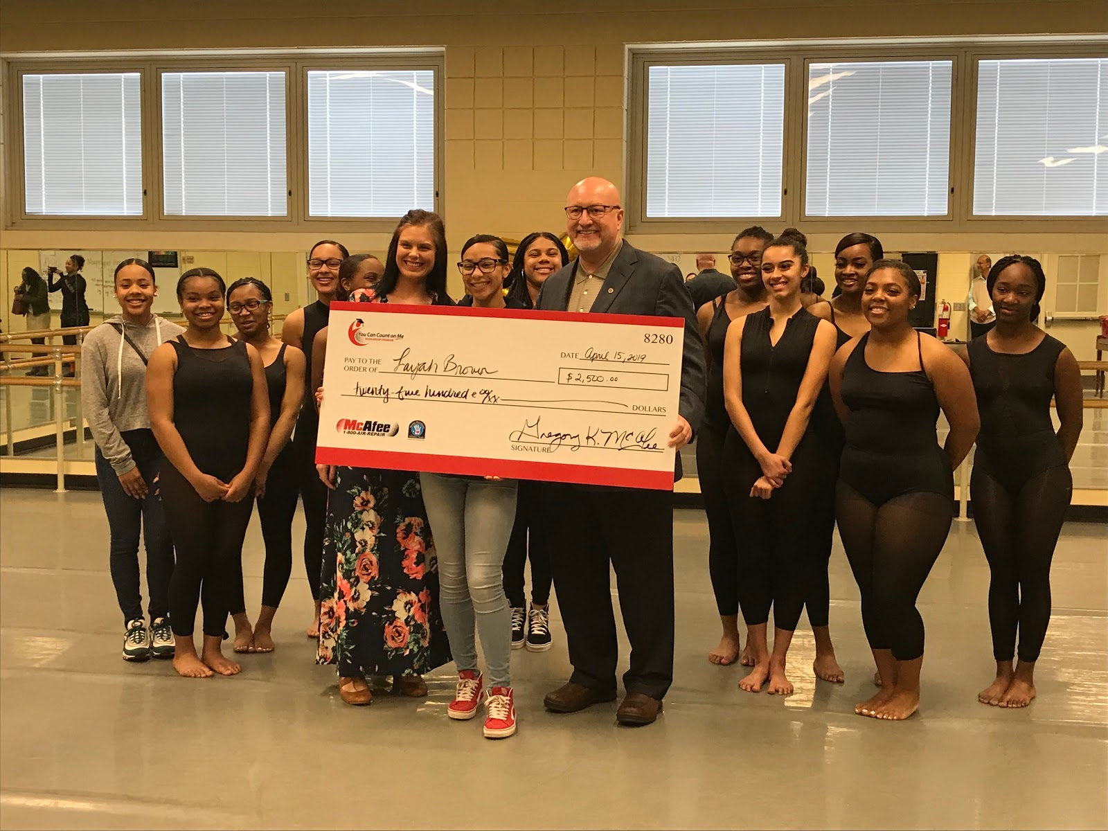Layah Brown and her Stivers Dance class pose with Greg McAfee and scholarship check