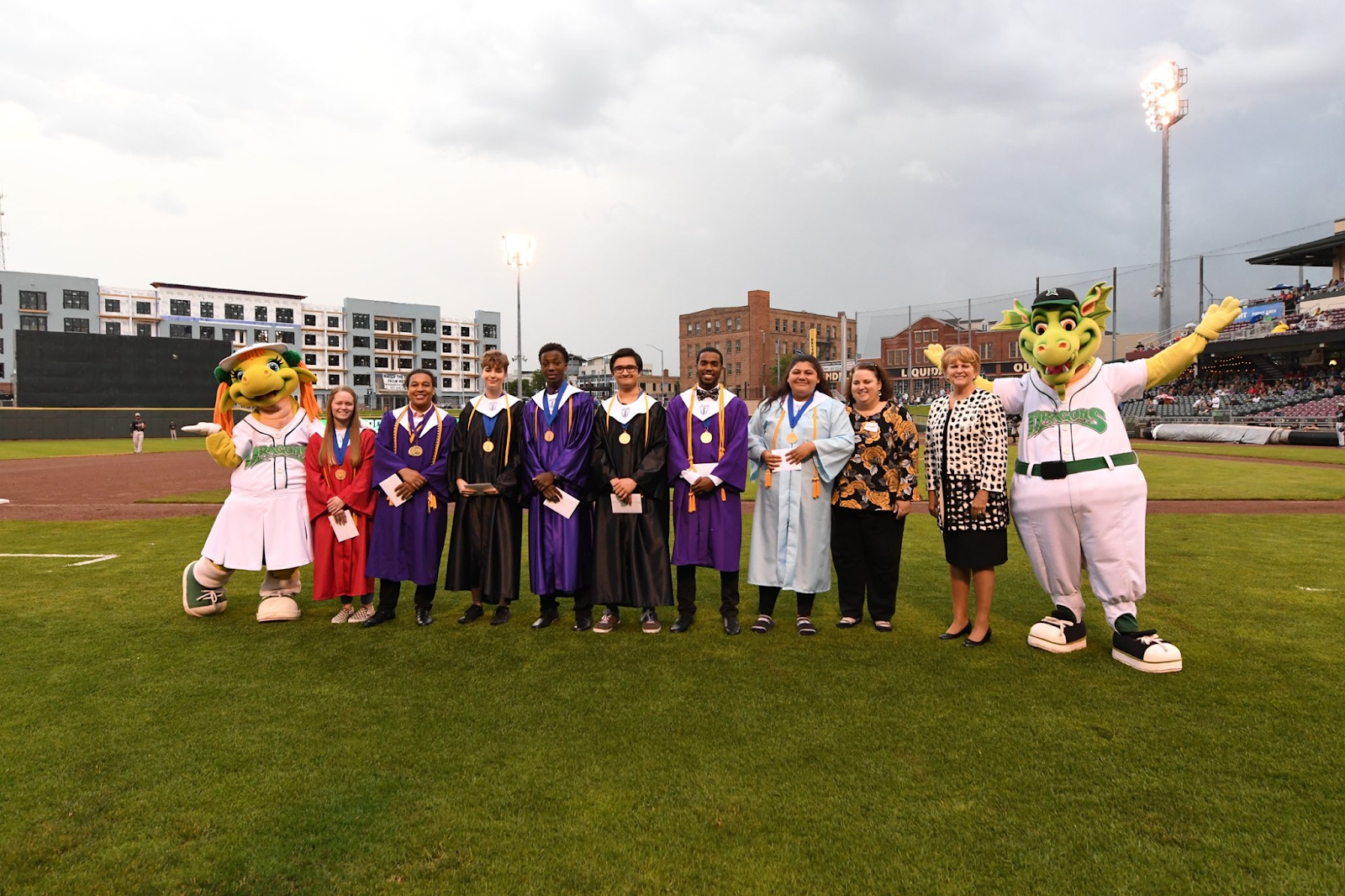 Valedictorians and Salutatorians posing with Dayton Dragons mascots Heater and Gem